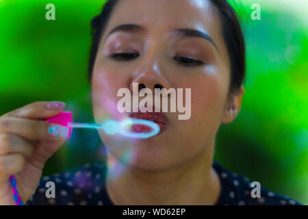 Schöne junge asiatische Frau mit Blasen Blase in der Stadt im Freien. Konzentrieren Sie sich auf die Lippen. Hochauflösende Bilder Galerie. Stockfoto