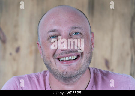 Closeup Shooting für mittleren Alters kaukasischen glatzköpfige Mann, der gerade in die Kamera schauen. Menschen und Lifestyle Konzept. Porträt der Mann mittleren Alters im Innenbereich Stockfoto