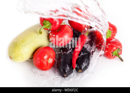 Tomaten, rote Paprika, red hot chili peppers, violette Auberginen, Zucchini in grün Tropfen Wasser auf weißem Hintergrund closeup Draufsicht isoliert Stockfoto