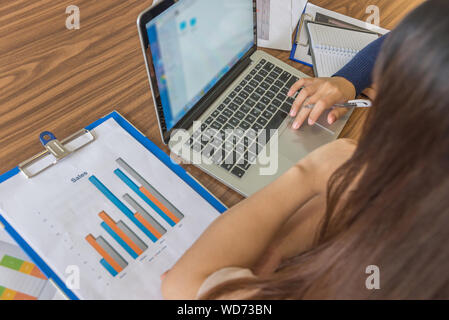 Hohe Betrachtungswinkel von Unternehmerinnen mit Laptop während der Diskussion in Stockfoto