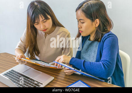 Zwei weibliche Finanzberater in Diskussion über geschäftliche Daten Dokumente Stockfoto