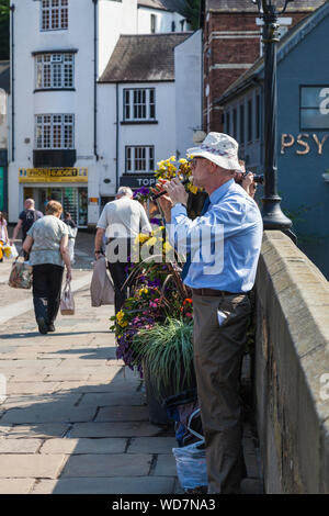 Ein reifer Mann spielt einen Penny whistle auf Framwellgate Brücke in Durham, England, Großbritannien Stockfoto