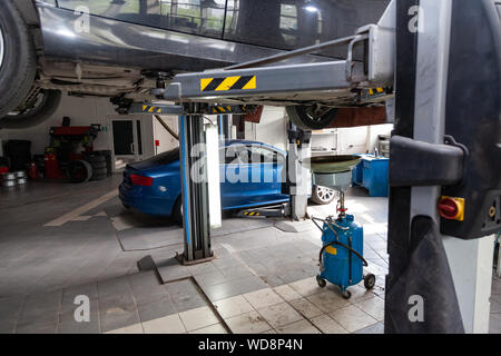 Verwendet carraised auf eine Hebebühne für die Instandsetzung des Chassis und Motor in einem Fahrzeug Werkstatt. Auto Service und Wartung Stockfoto