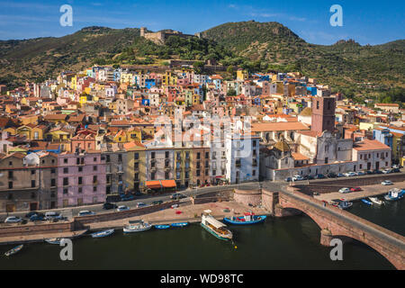 Bunte Häuser am Hang in der mittelalterlichen Stadt Bosa, Sardinien, Italien. Wunderschöne mediterrane Altstadt mit Burg auf dem Hügel. An unten, Fluss Temo mit Bo
