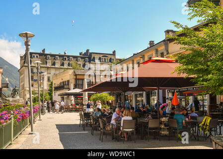 Blick auf die Straße des historischen Zentrums von Chamonix-Mont-Blanc mit Touristen am Café im Freien an einem sonnigen Sommertag sitzt, Haute Savoie, Alpen, Frankreich Stockfoto