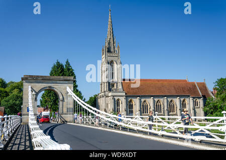 Eine Ansicht von Marlow Suspension Bridge entlang der Brücke an Allerheiligen Kirche hinaus an einem Sommertag mit einem blauen Himmel. Stockfoto