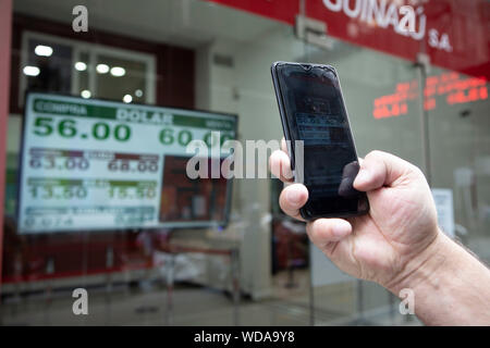 Buenos Aires, Argentinien. 28 Aug, 2019. Ein Fußgänger nimmt Bilder der Wechselkurs auf einem Bildschirm in Buenos Aires, Argentinien, Aug 28, 2019 angezeigt. Argentinien der Internationale Währungsfonds (IWF) gefragt, spricht über die Umstrukturierung seiner Schulden auf der 56-Milliarden-US-Dollar Bailout Darlehen im letzten Jahr vereinbart, Finanzminister Hernán Lacunza sagte Mittwoch. Quelle: Martin Zabala/Xinhua/Alamy leben Nachrichten Stockfoto