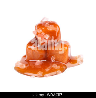 Gesalzen Karamell Bonbons und Soße, auf weißem Hintergrund. Leckere Karamell. Stockfoto