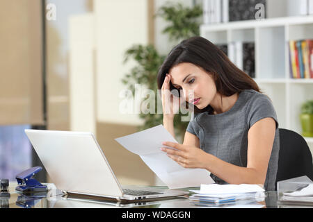 Besorgt Büroangestellter beschweren Lesen schlechte Nachrichten in einem Papier schreiben Stockfoto