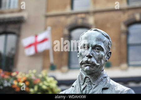 Eine Statue von Edward Elgar in der Mitte der Great Malvern, Worcestershire, mit Englischer Flagge im Hintergrund. Stockfoto