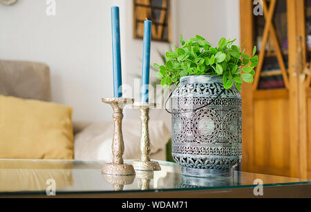 Nahaufnahme von Dekorationsartikeln (Kerzenständer und eine ethnische Pot) in ein gemütliches Wohnzimmer. Interior Design. Stockfoto