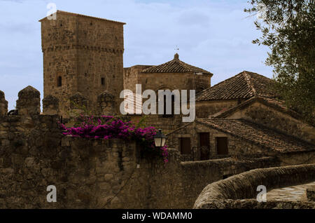 Wunderschöne Aussicht auf das Dorf von Trujillo, Caceres, Extremadura, Spanien mit einem fuchsia Bougainvillea wachsende gegen eine Mauer aus Stein Stockfoto