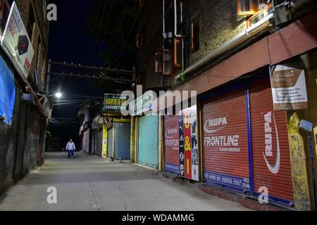 Srinagar, Indien. 28 Aug, 2019. Ein Mann hinter geschlossenen Geschäfte während der Schließung in Srinagar, Kashmir. Kaschmir-tal für die 24 nachfolgenden Tag blieb nach der Nichtigerklärung der besondere Status von Jammu und Kaschmir und die Bifurkation abgeschaltet. Credit: SOPA Images Limited/Alamy leben Nachrichten Stockfoto