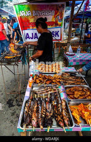 Filipino Street Food, eine philippinische Mann Kochen Fisch auf dem Grill, Dinagyang Festival, Iloilo City, Panay Island, Philippinen Stockfoto