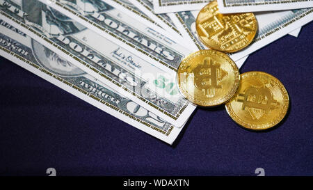 Bitcoins auf dem Hintergrund der Dollar. olden Bitcoins. Neue virtuelle Geld. symbolische Münzen von bitcoin auf Banknoten von einhundert Dollar. Austausch Stockfoto