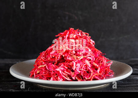 Rohe rote Beete, Karotten und Kohl Salat auf dem schwarzen Hintergrund Stockfoto