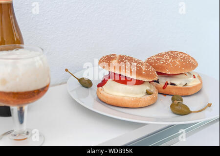 Hausgemachte Käse Burger auf Platte und ein Glas Bier. Bild horizontal. Stockfoto