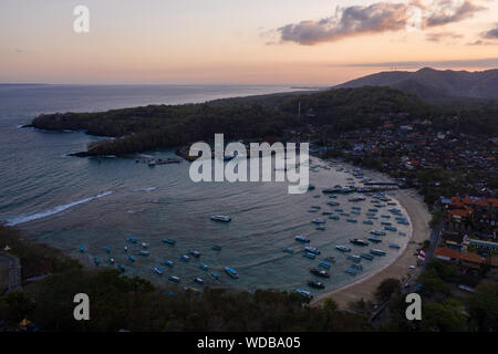 Luftaufnahme der Sonnenuntergang über der atemberaubenden Padangbai Bucht, Strand und Fährhafen in Bali, Indonesien Stockfoto