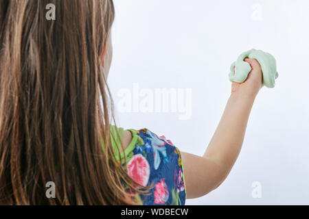 Girl Holding hausgemachten grünen Schleim. Auf weissem Hintergrund. Ansicht von hinten Stockfoto