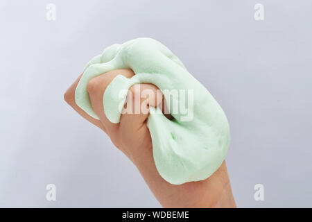 Hand zusammendrücken grünen Schleim. Auf weissem Hintergrund. Stockfoto