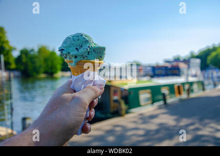 Eine männliche Hand mit einem Kegel von Minze und Choc Chip Eis Stockfoto