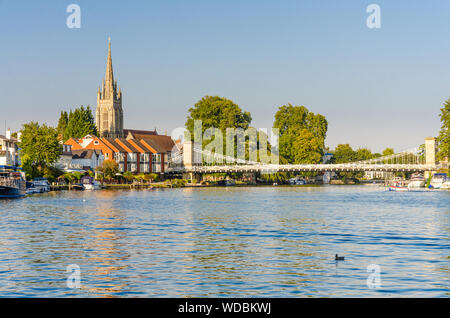 Ein Blick entlang der Themse von der Themse weg in Richtung Marlow in Buckinghamshire mit allen Heiligen Kirche und Marlow Suspension Bridge. Stockfoto