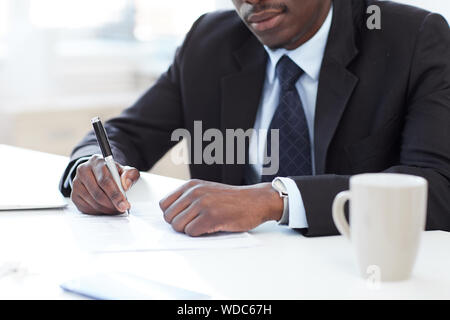 Nahaufnahme der afrikanischen Unternehmer sitzen im Büro der die Feder und die Unterzeichnung eines Business Vertrag Stockfoto