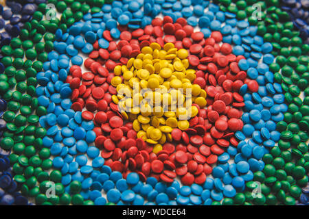 Industrielle bunte Polymere Farbstoff. Kunststoffgranulat. Farbmittel für Kunststoffe. Pigment in der Kunststoff Polyethylen Granulat Hintergrund Textur. Stockfoto