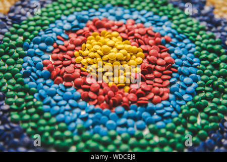 Industrielle bunte Polymere Farbstoff. Kunststoffgranulat. Farbmittel für Kunststoffe. Pigment in der Kunststoff Polyethylen Granulat Hintergrund Textur. Stockfoto
