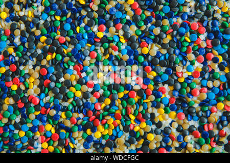 Industrielle bunte Polymere Farbstoff. Kunststoffgranulat. Farbmittel für Kunststoffe. Pigment in der Kunststoff Polyethylen Granulat Hintergrund Textur. Stockfoto