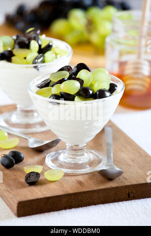 Paar Gläser der griechischen Joghurt mit roten und weißen Trauben Stockfoto