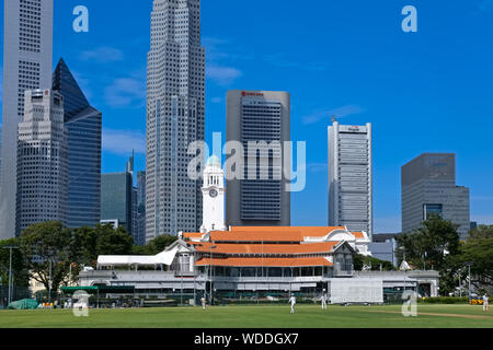 Blick über die Padang in Richtung Singapur Cricket Club, Victoria Memorial Hall & Theater mit seinem Uhrturm und das Bankenviertel darüber hinaus; Singapur Stockfoto