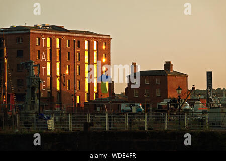 Sonnenlicht spiegelt sich in den Fenstern der Tate Liverpool in der Abenddämmerung. Stockfoto