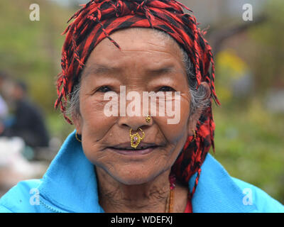 Ältere Nepali Rai Frau mit gebrochenen Nase Tribal Schmuck posiert für die Kamera. Stockfoto