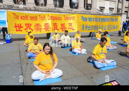 Mitglieder der Falun Gong meditieren vor der National Gallery am Trafalgar Square während des Protestes. Demonstration gegen ihre Verfolgung in China. Falun Gong ist Chinesische religiöse spirituelle Praxis, dass Meditation und Gong Übungen, kombiniert mit einer moralischen Philosophie auf die Grundsätze von Wahrhaftigkeit, galoppierte, Mitgefühl und Nachsicht. Stockfoto