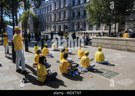 Mitglieder der Falun Gong meditieren vor der National Gallery am Trafalgar Square während des Protestes. Demonstration gegen ihre Verfolgung in China. Falun Gong ist Chinesische religiöse spirituelle Praxis, dass Meditation und Gong Übungen, kombiniert mit einer moralischen Philosophie auf die Grundsätze von Wahrhaftigkeit, galoppierte, Mitgefühl und Nachsicht. Stockfoto