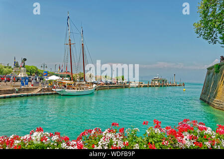 Kai und der Fluss Mincio fließt vom Gardasee in Peschiera del Garda, Venetien, Italien. Stockfoto