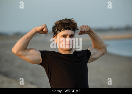 Junge männliche erwachsene Portrait an goldenen Stunde am Strand Stockfoto