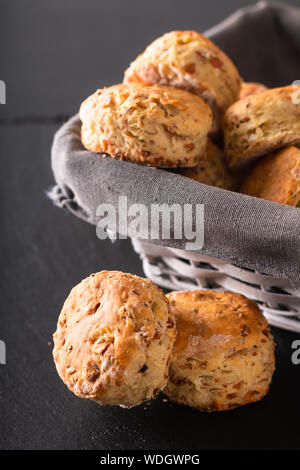 Essen Konzept Frische hausgemachte buttrig, salzigen Schinken und Käse Scones auf schwarzem Hintergrund Stockfoto