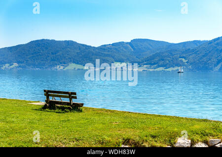 Schöne Aussicht auf den Attersee im Salzkammergut Alpen Berge, Sitzbank, Boot, Segelboot in Nussdorf, Zell am Attersee. Oberösterreich, in der Nähe Salzburg Stockfoto