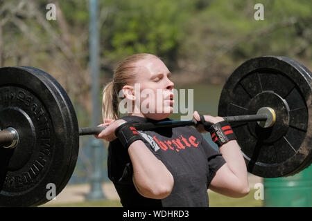 Weibliche oder Frau in einer CrossFit Fitness Challenge Wettbewerb durch tote Gewichte zu heben oder Gewichtheben konkurrieren. Stockfoto