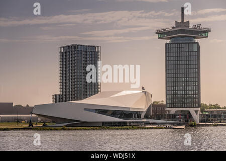 Amsterdam, Niederlande - 30. Juni 2019: White Eye Film Museum, ein 'Dam Aussichtsturm auf der rechten Seite, Clinknoord Turm unter Morgen lighte Links Stockfoto