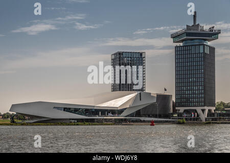 Amsterdam, Niederlande - 30. Juni 2019: White Eye Film Museum, ein 'Dam Aussichtsturm auf der rechten Seite, Clinknoord Turm unter Morgen lighte Links Stockfoto