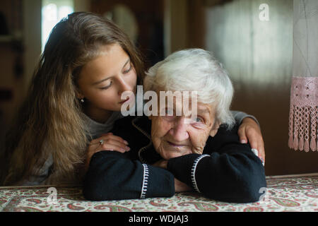 Porträt der alten Frau c geliebte Enkeltochter im Haus. Stockfoto