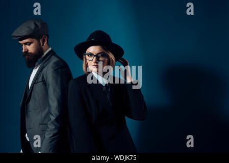 Der Mann und die Frau in der altmodischen Anzug und Hut auf dunklem Hintergrund. Paar Detektive oder Forscher, private Ermittler. Paar in Liebe oder Arbeit teil Stockfoto
