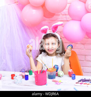 Die Werte der Familie, Kindheit, Kunst Ostern, Kind in rosa Hasenohren. Happy Family feiern Frühling Urlaub, Liebe. Frohe Ostern mit kleinen Mädchen malen Eier. Stockfoto