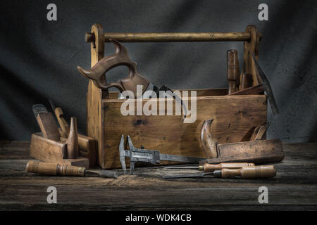 Immer noch leben - altes Holz vintage Werkzeugkoffer mit Hammer, Säge, Meißel, Flugzeug und Zange in der Schreinerei Stockfoto