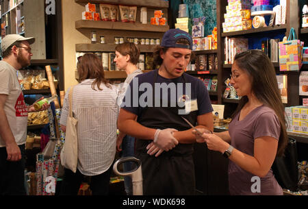 Madison, WI USA. Apr 2018. Junge ladiy Hilfe von Personal an der Entscheidung über kompatible Nahrungsmittel. Stockfoto