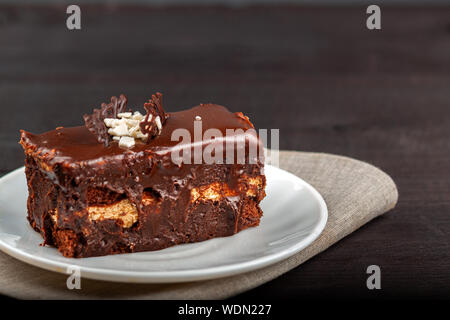 Teller mit einem Stück Schokolade Kuchen steht auf einem Holztisch Stockfoto