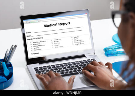 Afrikanische Frauen füllen Patienten Informationen Formular auf Digital Laptop über Weiß Schreibtisch Stockfoto